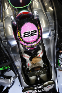 Jenson Button sits in his car in the garage.