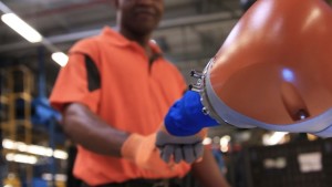 Car Workers and Mini Robots Work Hand in Hand